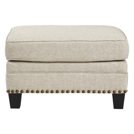 Ottoman en tissu beige effet lin avec garniture cloutée - Claredon